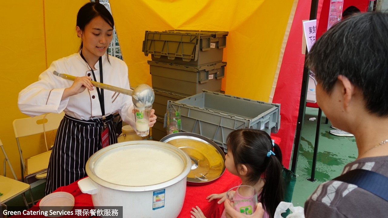 The food stall operator serving drinks to the event participants by using reusable cups